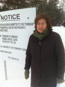 Gerry OIdham stands in front of the "notice of meeting" sign posted on the King Street Parkette property.