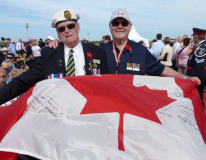 Bill Opitz (left), D-Day vet from Canadian minesweeper Bayfield, receives Rick Askew's commemorative flag at Juno Beach on June 6, 2014.